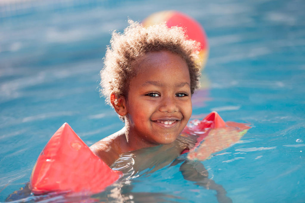 παιδί με μανίκι επιπλέει κολύμπι στην πισίνα  - Φωτογραφία, εικόνα