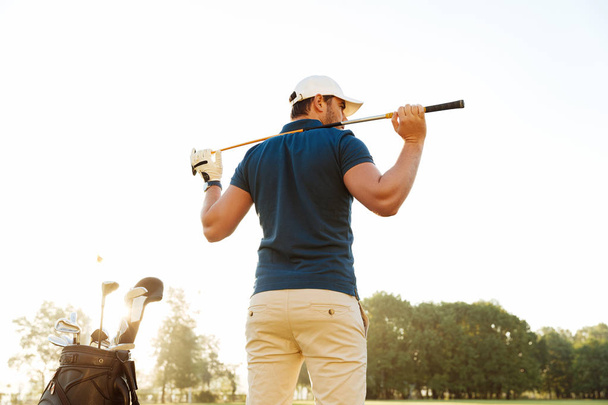Back view of a male golf player at the course with a club sack - 写真・画像