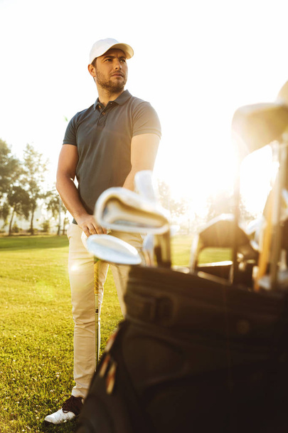 Male golf player at the green course with a club sack - Foto, Imagen