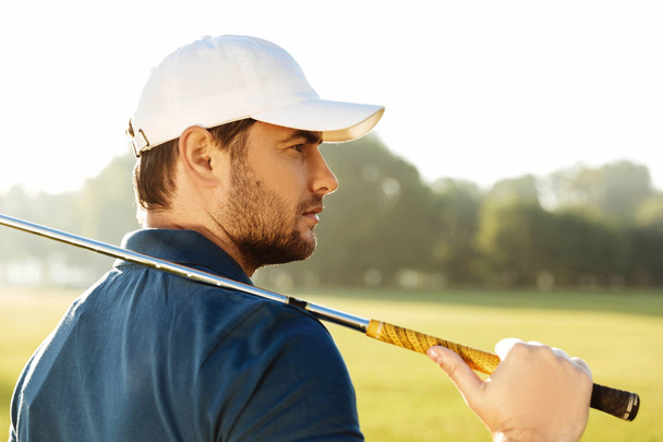 Close up of a young handsome male golfer in hat - 写真・画像