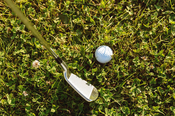 Close-up of golf ball with golf club before tee off - 写真・画像