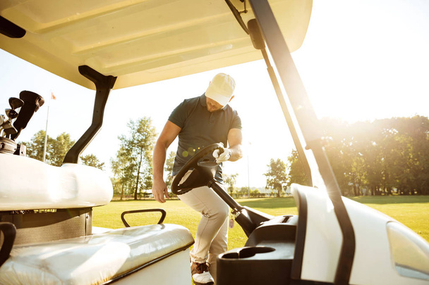 Mężczyzna golfa w wózek golfowy - Zdjęcie, obraz