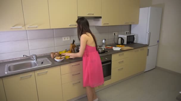 Girl hurries and runs from the kitchen with sandwich to work - Кадры, видео