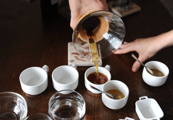A folyamat a kávé köpölyözés. Kávé öntenek kóstoló csésze - Fotó, kép