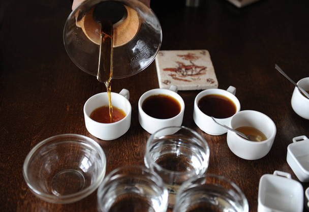 A folyamat a kávé köpölyözés. Kávé öntenek kóstoló csésze - Fotó, kép