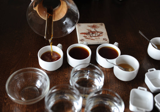 Il processo di coppettazione del caffè. Il caffè viene versato in tazze di degustazione
 - Foto, immagini