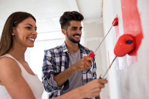 Lovely smiling happy couple painting new home - Photo, image