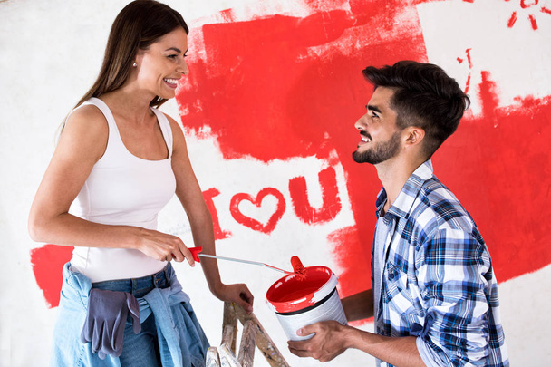Lovely smiling couple painting new home,new house renovation - Valokuva, kuva