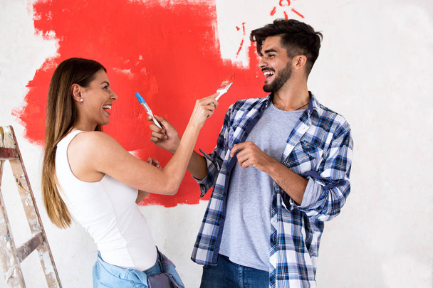 Smiling funny couple doing painting - Zdjęcie, obraz