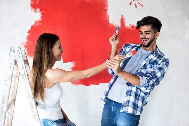Забавная привлекательная пара, играющая с цветовыми кисточками
 - Фото, изображение