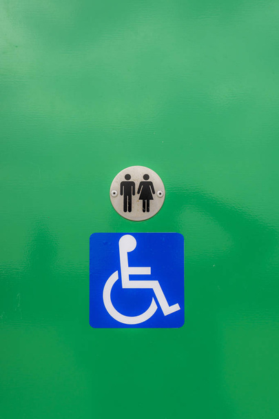 Segno di toilette per disabili, sullo sfondo verde
 - Foto, immagini