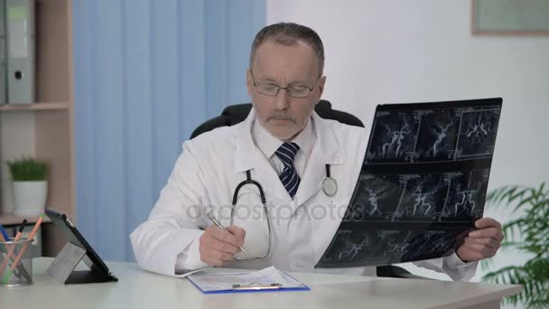 Neurologist checking angiography of blood vessels, making description in cards - Video