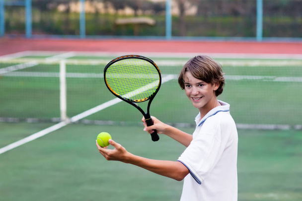 Child playing tennis on outdoor court - Photo, Image