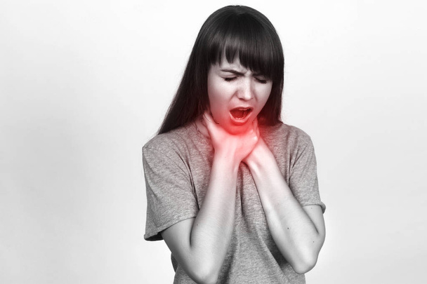 Mujer joven con dolor de garganta en blanco y negro con acento rojo
 - Foto, Imagen