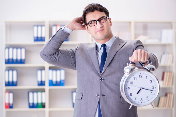 Businessman with alarm clock in the office - Photo, Image