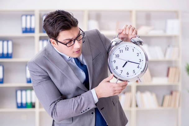 Businessman with alarm clock in the office - Photo, Image