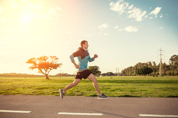urheilija juoksee puistossa auringonlaskussa
 - Valokuva, kuva