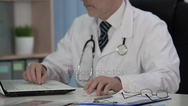 Doctor of Medical Science writing scientific article for magazine, using laptop - Video, Çekim