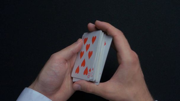 Juego de póquer - barajar cartas. Manos de hombre barajando cartas. De cerca. Manos de hombre barajando naipes. Distribuidores manos barajando cartas durante un juego de póquer
 - Foto, imagen