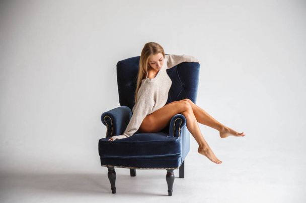 sexy woman sitting on the blue armchair  - Фото, изображение