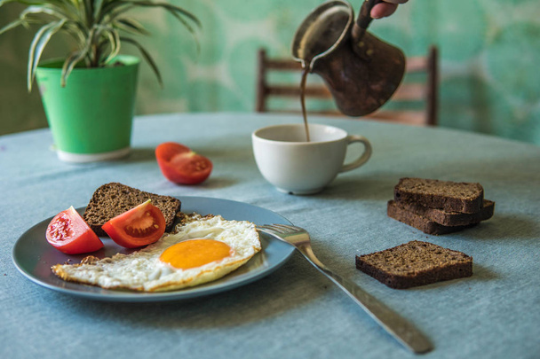 Ontbijt, gebakken eieren en tomaten. Koffie uit cezve - Foto, afbeelding