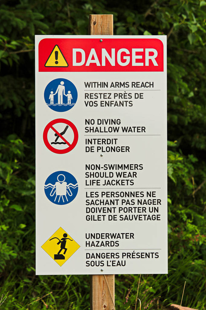 Una señal de peligro con varias reglas de playa
 - Foto, Imagen