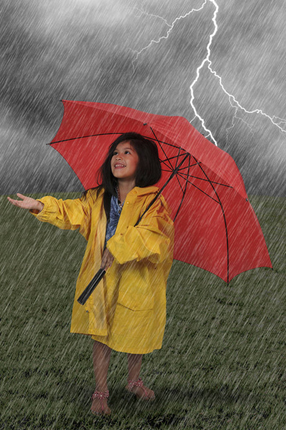 Tyttö sadetakki tilalla sateenvarjo
 - Valokuva, kuva