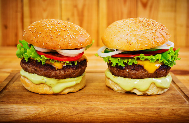 köstliche handgemachte Burger auf Holzgrund. Ansicht schließen - Foto, Bild