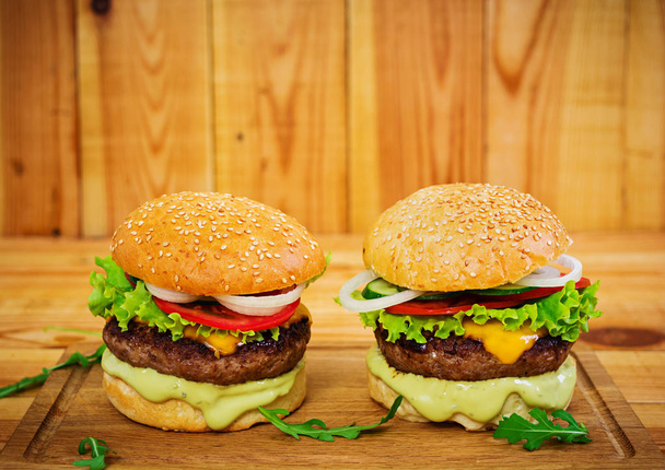 Smacznego hamburgera ręcznie robione na podłoże drewniane. Zamknij widok - Zdjęcie, obraz