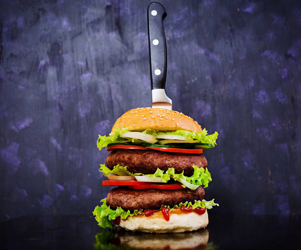Smacznego hamburgera ręcznie robione na ciemnym tle. Zamknij widok - Zdjęcie, obraz