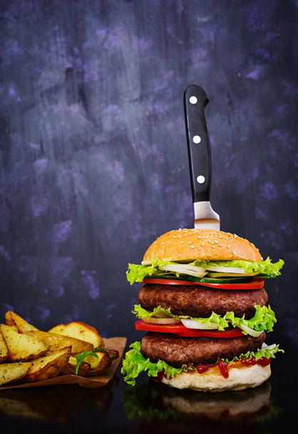 Smacznego hamburgera ręcznie robione na ciemnym tle. Zamknij widok - Zdjęcie, obraz