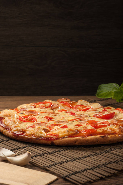 Heerlijke verse pizza geserveerd op houten tafel - Foto, afbeelding