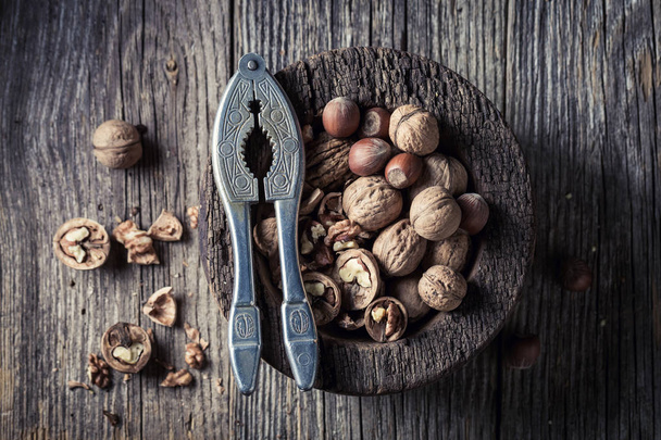 Свежие грецкие орехи и фундук на деревенском деревянном столе
 - Фото, изображение