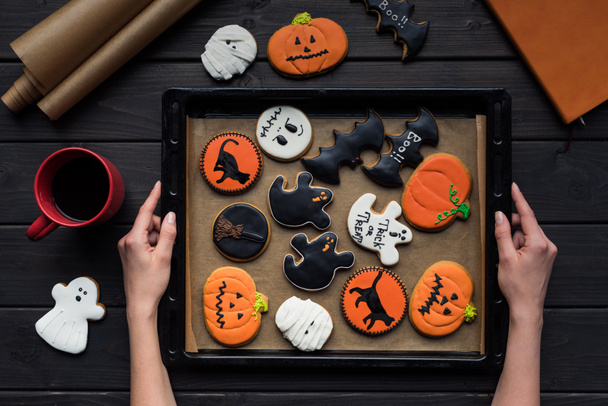 woman holding tray of halloween cookies - Fotó, kép