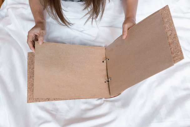 Азіатські жінки руки пусті коричневий перегортання сторінок на білу ліжко - Фото, зображення