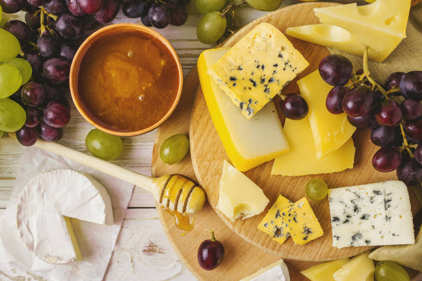 Cheese plate served with honey, fresh grapes and pears - Foto, Imagen