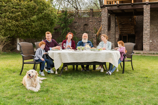 família jantando no campo
 - Foto, Imagem