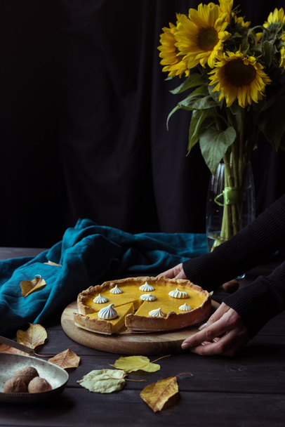 manos femeninas colocando pastel en la mesa
 - Foto, Imagen