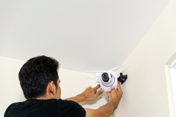 Techniker installieren eine drahtlose Videokamera auf dem Dach - Foto, Bild