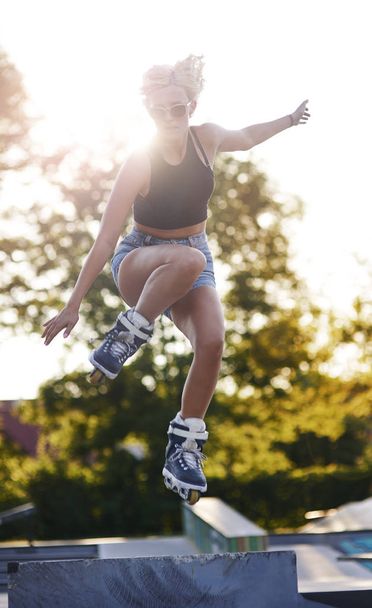 Tyttö hyppii rullaluistimilla
 - Valokuva, kuva