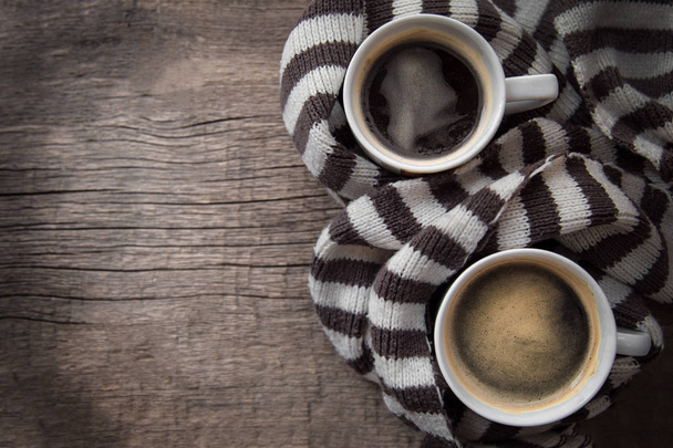 two mugs of hot coffee with foam standing on a wooden background - Фото, зображення