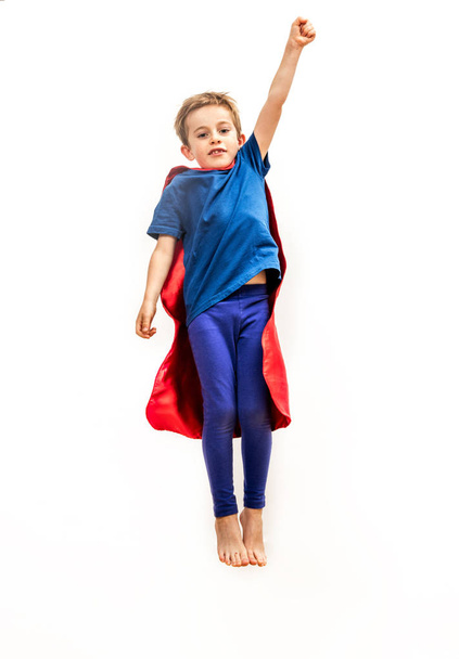 Isolated kid reaching high like powerful superhero, pretending reaching something - Фото, изображение