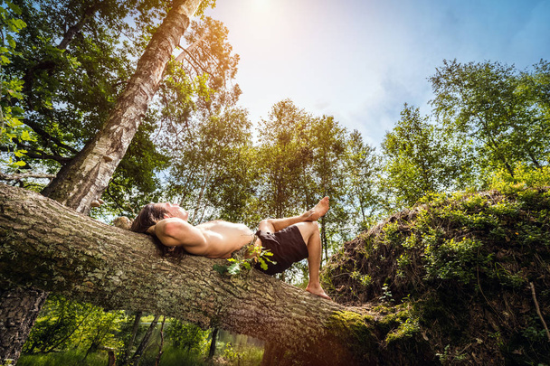 Mladý muž ležel a relaxaci v lese. - Fotografie, Obrázek