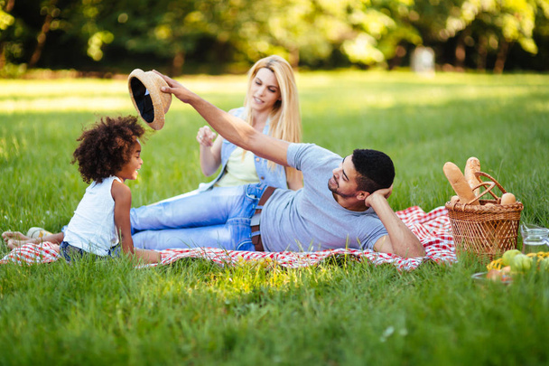 Picture of lovely couple with their daughter having picnic - Foto, afbeelding