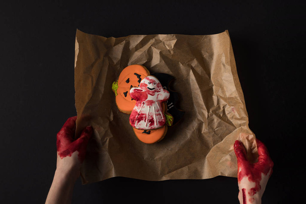 hands wrapping halloween cookies - Zdjęcie, obraz
