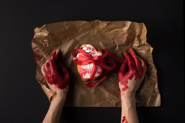 hands wrapping halloween cookie - Foto, Imagem