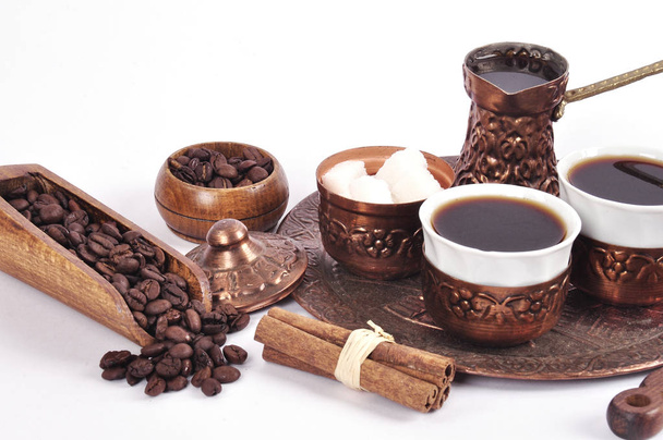Кофе в медных берегах с принадлежностями для питья кофе
 - Фото, изображение