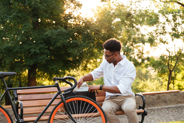 Concentrated young african man early morning with bicycle - Photo, Image
