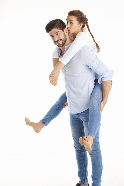  man giving piggyback to girlfriend.  - Valokuva, kuva