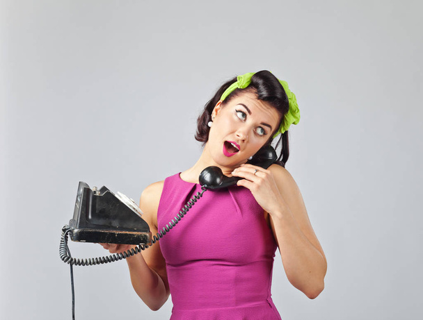 Beautiful woman in pin up style with vintage phone. - Zdjęcie, obraz